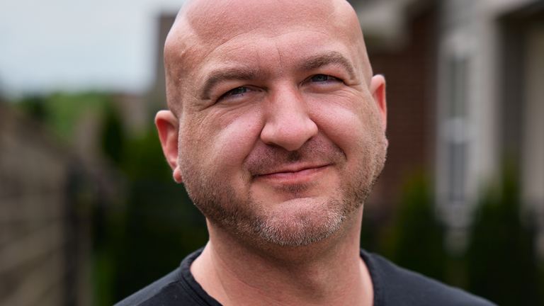 Nick Cavuoto smiling in a studio portrait.